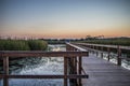 Sun setting over a long boardwalk through the marsh Royalty Free Stock Photo