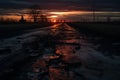 the sun is setting over a muddy road