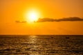 The sun is setting over the ocean, casting a warm glow on the water Royalty Free Stock Photo