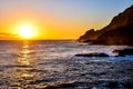 The sun is setting over the ocean, casting a warm glow on the water Royalty Free Stock Photo