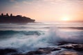the sun is setting over the ocean with waves crashing on the rocks and a castle in the distance in the distance is a body of Royalty Free Stock Photo