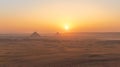 The sun is setting over the pyramids of Egypt Royalty Free Stock Photo