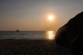 Sun setting over thailand ocean with yacht in background