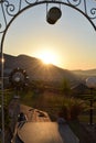 The sun setting over the Turkish mountain seen through a archway that looks over the garden
