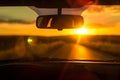 sun setting in the rearview mirror, driver silhouetted Royalty Free Stock Photo