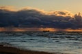 Sun setting at the sea with sailing cargo ship, scenic view. Clouds and storming sea. Defocused. Royalty Free Stock Photo