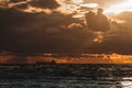 Sun setting at the sea with sailing cargo ship, scenic view. Clouds and storming sea. Defocused. Royalty Free Stock Photo