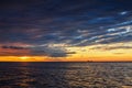 Sun setting at the sea with sailing cargo ship, scenic view Royalty Free Stock Photo