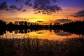 Sun setting with silhouette trees and bush around the big pond in rural of Thailand, shot taken by using long exposure therefore s