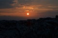 The sun setting slowly between the clouds in the sky and behind the rocky mountains of Pamukkale, illuminating the Turkish sky Royalty Free Stock Photo