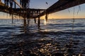 the sun setting underneath a pier in Raa, Helsingborg, Sweden Royalty Free Stock Photo