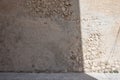 Sun shadow on old stone building wall background. Light and shadow texture on grunge shabby old brown stone wall and Royalty Free Stock Photo