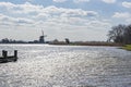 The sun shimmers in the choppy water of the lake De Rottemeren near windmill De Korenmolen on a sunny and windy day