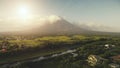 Sun shine over Mayon volcano erupts aerial. River at green grass hillside. Tropic forest at Legazpi Royalty Free Stock Photo
