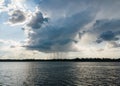 .The sun shines behind rain clouds over the river and the forest Royalty Free Stock Photo