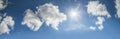 The sun shines on the blue sky among the white clouds Royalty Free Stock Photo