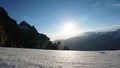 The sun shines brightly. View of snowy mountains, blue sky, cliff and white clouds.