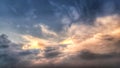 The sun shines through the clouds floating in the sky in the evening Royalty Free Stock Photo