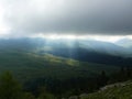 The sun shines through the clouds in the mountains in the valley Royalty Free Stock Photo