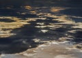 The sun shines through the clouds in the sunset sky with dramatic light. The shape of the clouds evokes imagination and creativity Royalty Free Stock Photo