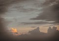 The sun shines through the clouds in the sunset sky with dramatic light. The shape of the clouds evokes imagination and creativity Royalty Free Stock Photo
