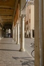 Sun shines on columns of covered walkway, Mantua, Italy