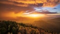 The sun shines through a gap in the cloudy sky and colours a departing thunderstorm in golden shades Royalty Free Stock Photo