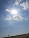 The sun shines between white clouds in a blue sky Royalty Free Stock Photo
