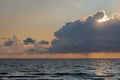 Dark fluffy cumulus clouds stormy sky above a blue surface of sea at sunset Royalty Free Stock Photo