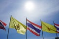 The sun is shining light over Thai national flags and His Majesty King Vajiralongkorn flags