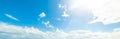 Sun shining over a blue sky with white clouds Royalty Free Stock Photo