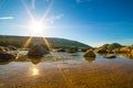 Sun shining over rocks on Jordon Pond in Acadia National Park, Maine