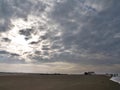 Sun shining through strong clouds on a nearly empty beach in Sankt Peter-Ording