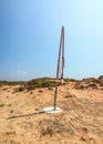 Sun shining to small broken wind power turbine in dry, desert like land. Post apocalyptic wasteland scene