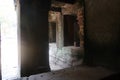 Sun shining through a window at stone pillar with ancient murals in famous histroical angkor wat ruins, cambodia Royalty Free Stock Photo