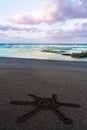 Sun Sign Drawn On Black Sand Of Beach