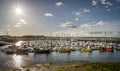 A sun with star rays shining over a port of sail boats. Royalty Free Stock Photo