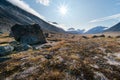 Sun star shines in the sky over remote, wild arctic valley of Akshayuk Pass, Baffin Island on a sunny summer day. Iconic