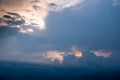 The sun started to shine with orange rays of light in the cloudy sky after the big thunderstorm. Royalty Free Stock Photo