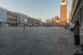 Sun still shining on Campanile brick tower in St Marks Square as street is in shade