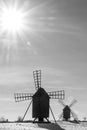 Sun and sunbeams by two old windmills Royalty Free Stock Photo