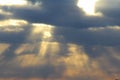 The sun at sunset or dawn behind the clouds, shines through. The sun`s rays in the sky Royalty Free Stock Photo