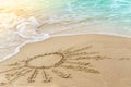 The sun symbol drawing on sand beach, covering foam turquoise wave of sea. Sunny summer vacation concept Royalty Free Stock Photo