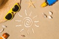 Sun tan lotion bottles and a drawing of the sun on the sand Royalty Free Stock Photo