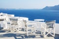 A sun terrace for rest with a white wooden table and chairs in Thira, Santorini island, Greece Royalty Free Stock Photo