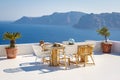 A sun terrace for rest with a wooden table and chairs in Thira, Santorini island, Greece Royalty Free Stock Photo