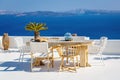 A sun terrace for rest with a wooden table and chairs in Thira, Santorini island, Greece Royalty Free Stock Photo