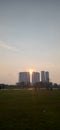 The sun that is about to set is seen between the two buildings Royalty Free Stock Photo
