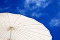 Sun umbrella on the beach against blue sky with clouds. Royalty Free Stock Photo