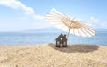 Sun umbrella and house on sandy beach, blue sky and sea in the background. Investment in resort real estate concept